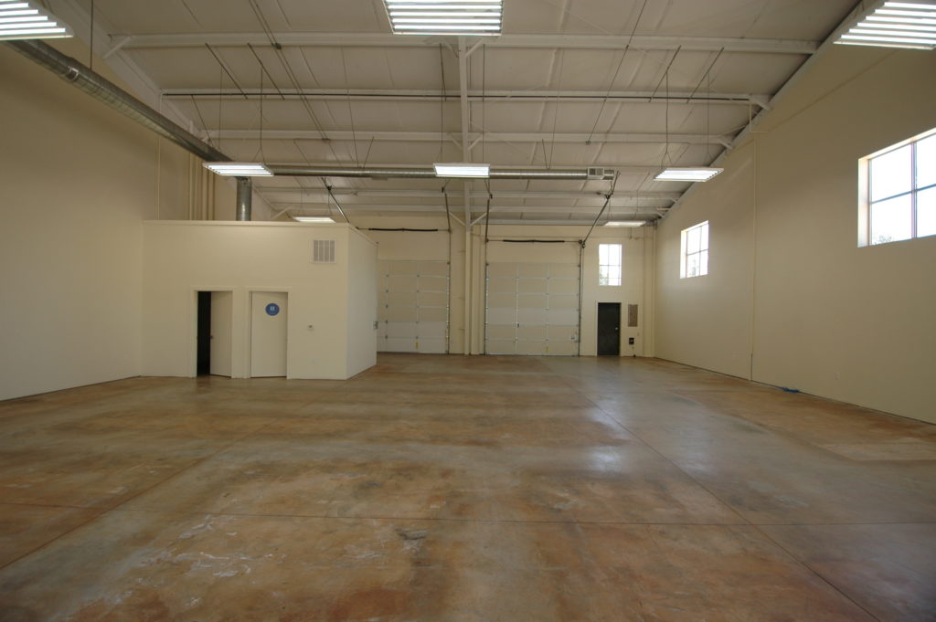 View of the interior of 357 Main Street. At rear of space you can see the two bathrooms, and two roll up doors.